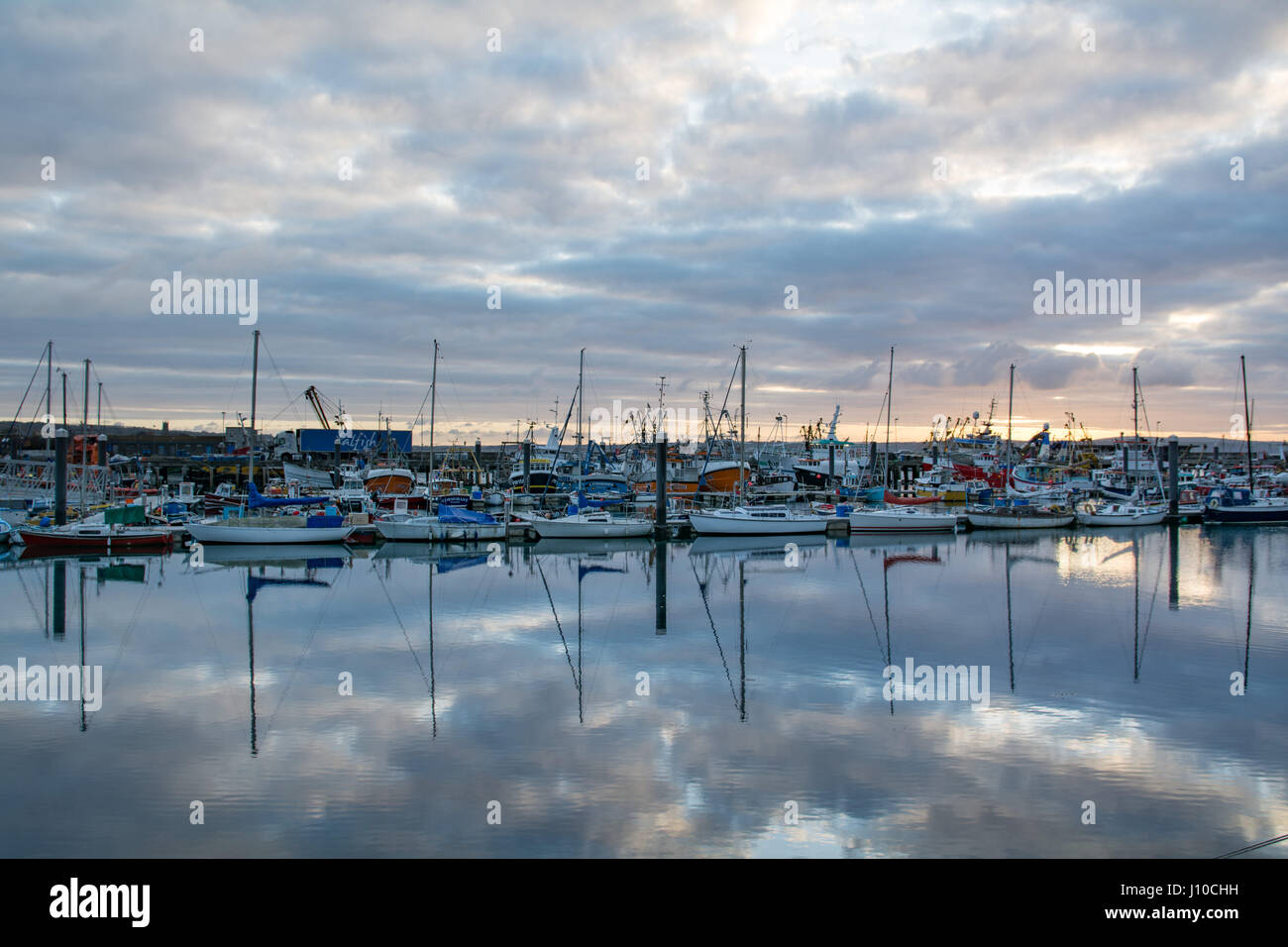 Newlyn, Cornwall, Regno Unito. Il 17 aprile 2017. Regno Unito Meteo. Nuvole che oscurano il mattino sunrise a Newlyn il lunedì di Pasqua. Tuttavia, le nuvole sono dovute a cancellare, lasciando un soleggiato ma nel pomeriggio più fredda rispetto a quella di fine. Credito: Simon Maycock/Alamy Live News Foto Stock