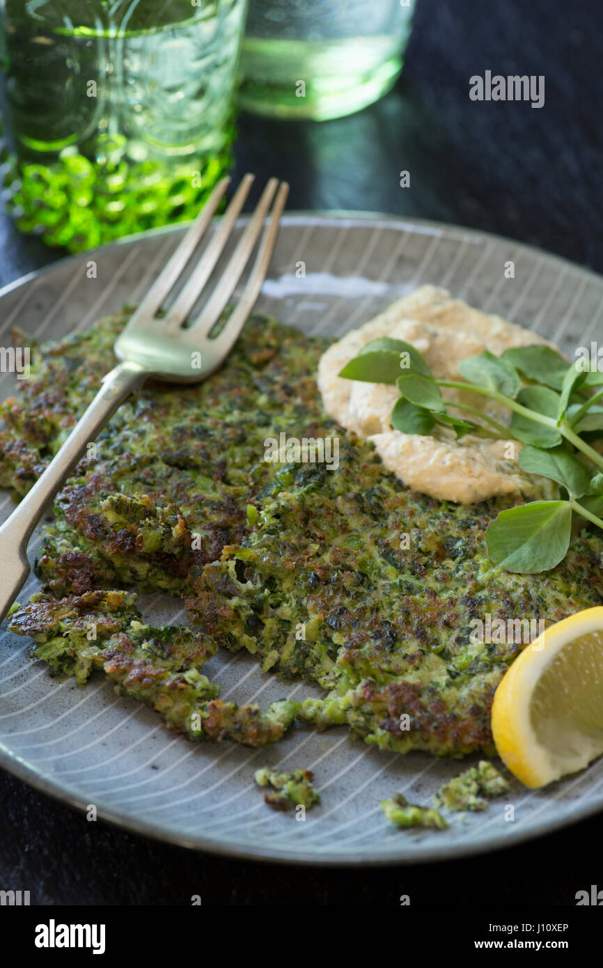 Cavoli rapa e frittelle di piselli con hummus e germogli di piselli Foto Stock