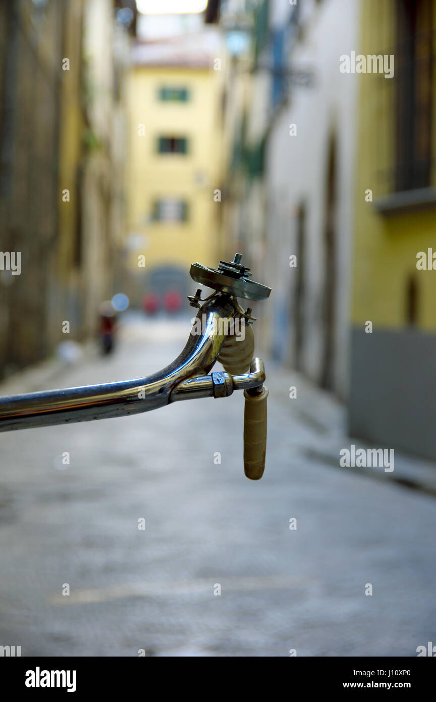 Manubrio di bicicletta dettaglio contro un bokeh Vicolo nel centro di Firenze (Firenze), Toscana, Italia, Europa - il fuoco selettivo sul manubrio Foto Stock