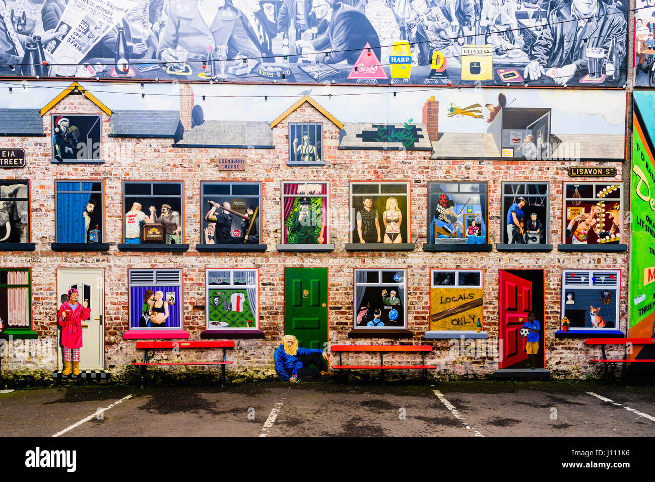Murale artistico su una parete a Belfast, raffigurante una fila di case a schiera con vista all'interno di ciascuna delle camere. Foto Stock