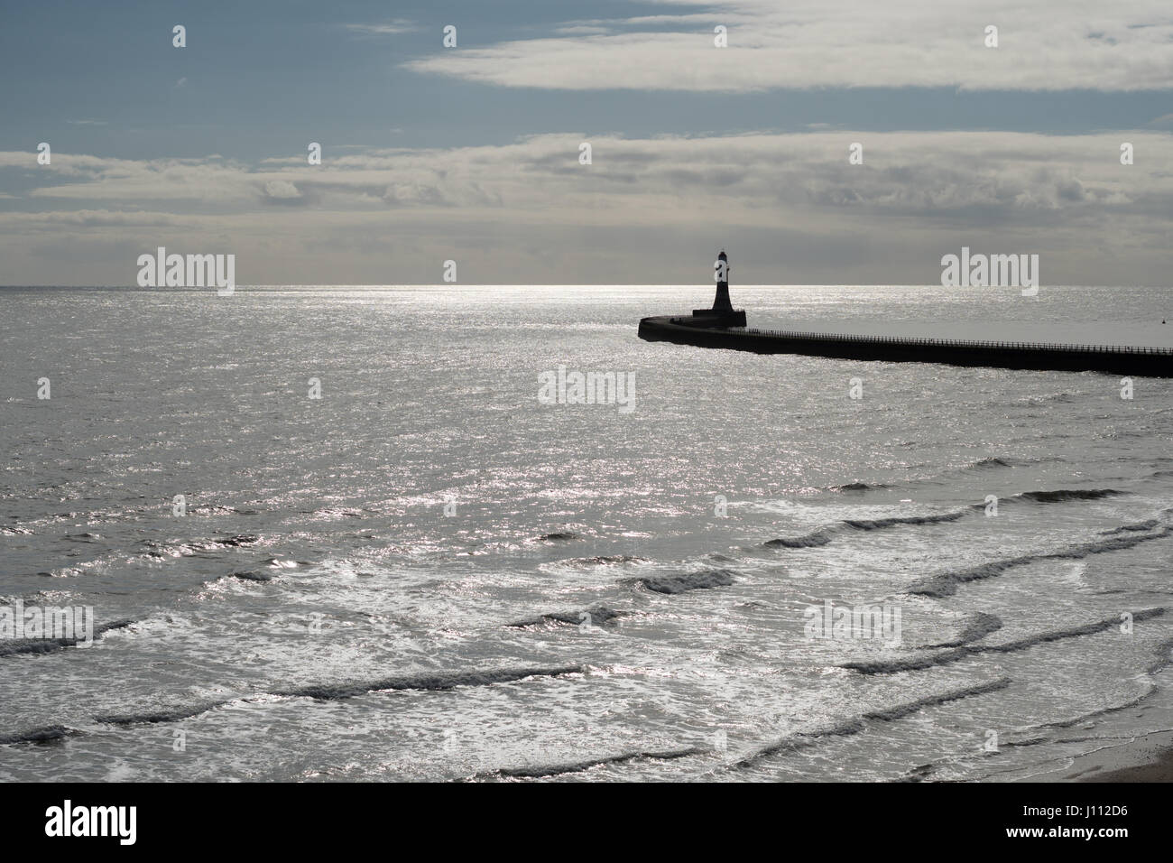 Roker Pier e il faro stagliano contro una scintillante Mare del Nord, Sunderland, England, Regno Unito Foto Stock