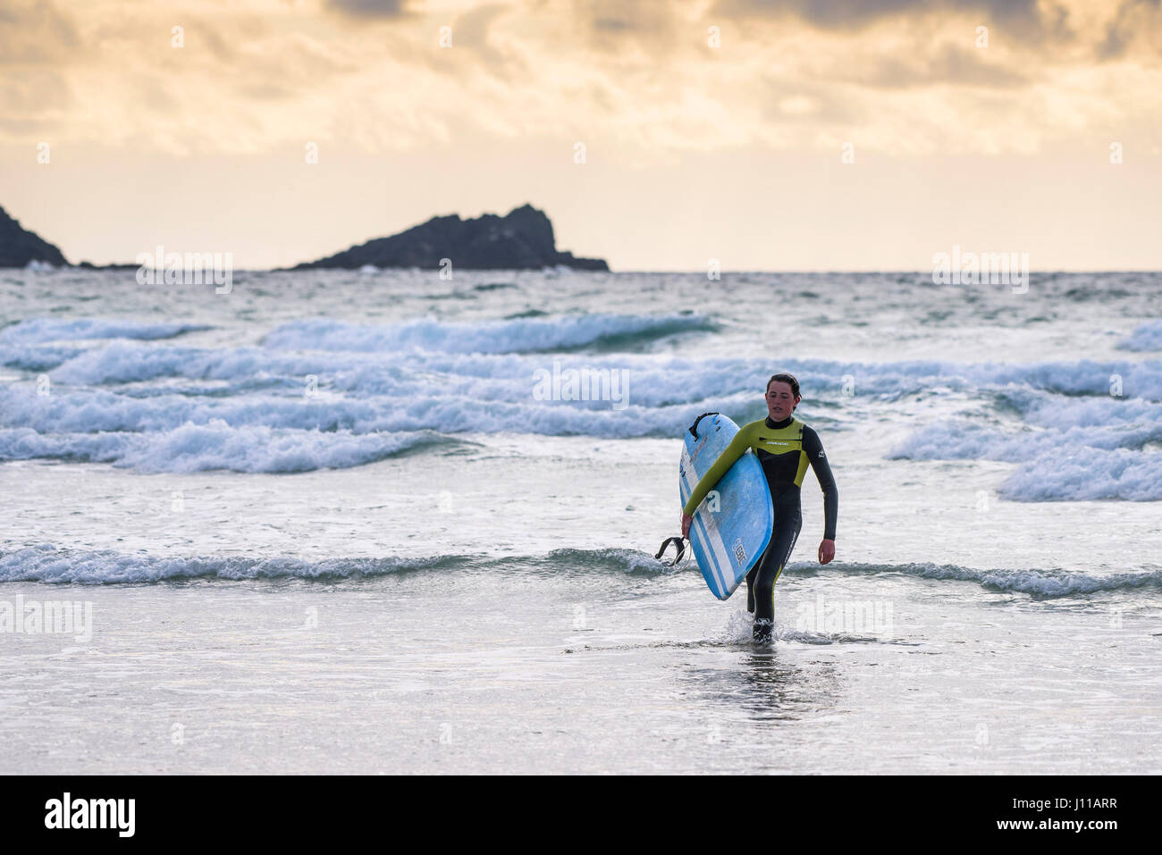Surf UK; Surfer; Fistral; Cornovaglia; camminare fuori del mare; realizzazione della tavola da surf; Mare; Sport acquatici; sera; stanco; le attività per il tempo libero; stile di vita Foto Stock