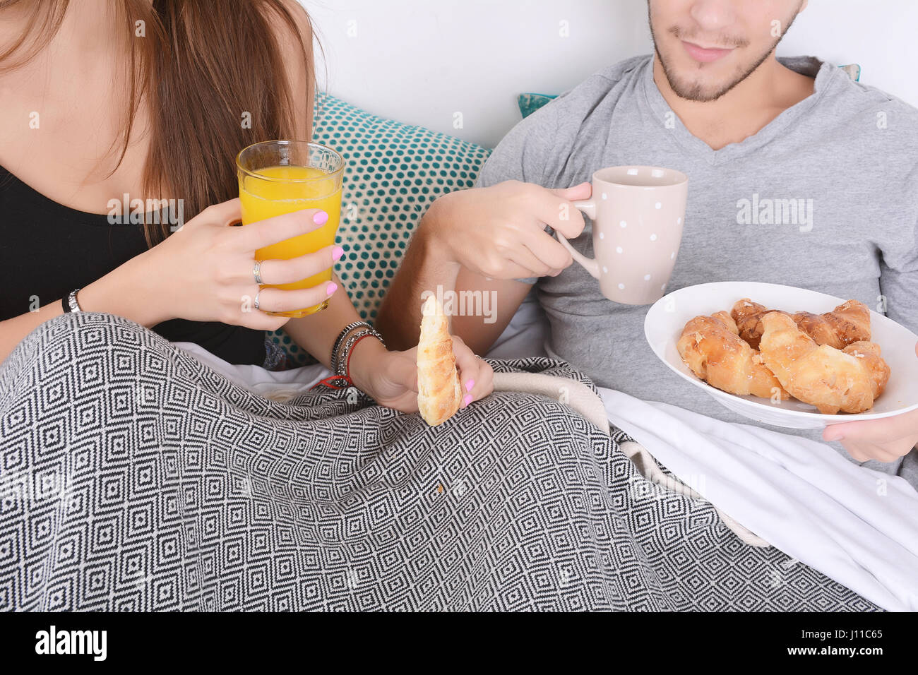 Bella coppia Giovane avente la colazione a letto. In ambienti chiusi. Foto Stock