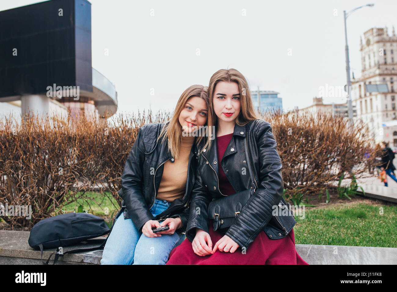 Due giovani amici ragazza seduta insieme e divertimento all'aperto. Stile di vita. Foto Stock