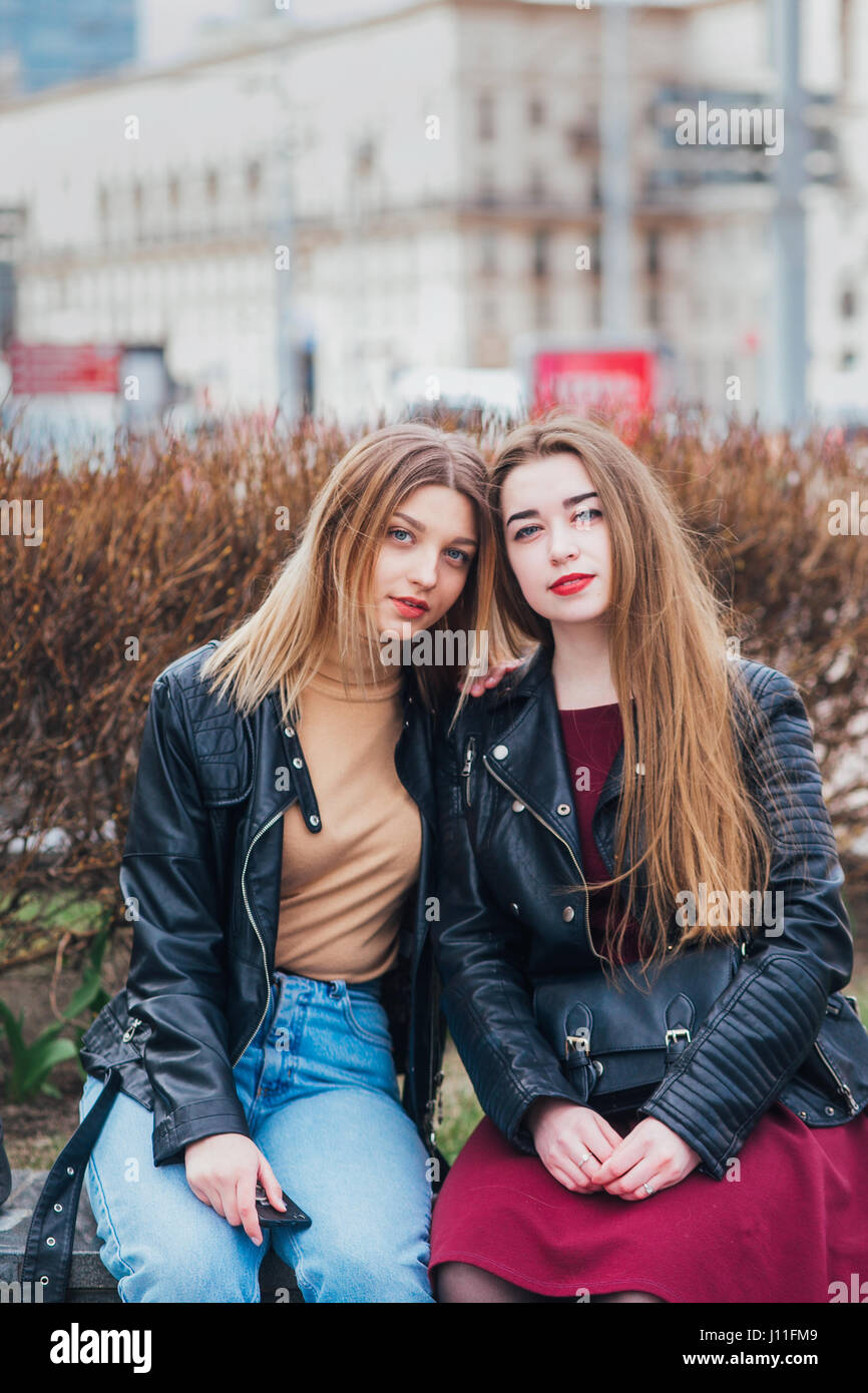 Due giovani amici ragazza seduta insieme e divertimento all'aperto. Stile di vita. Foto Stock