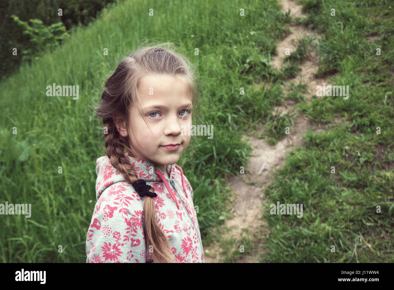 Bambino ragazza guardare indietro sul percorso esterno Foto Stock