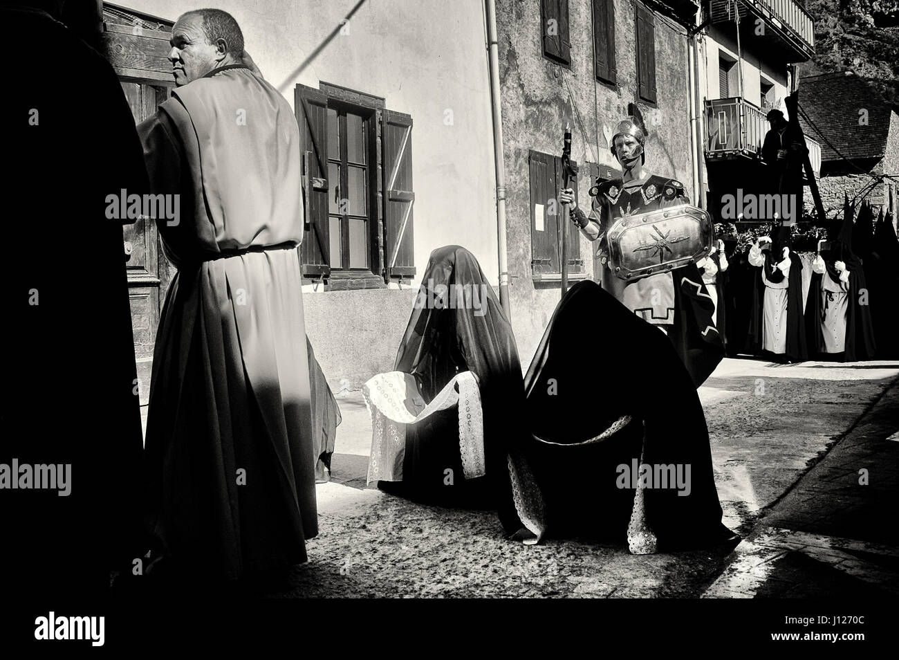 I penitenti prostrata sul pavimento durante la processione del Venerdì santo per le strade del villaggio dei Pirenei di Bossost. Foto Stock