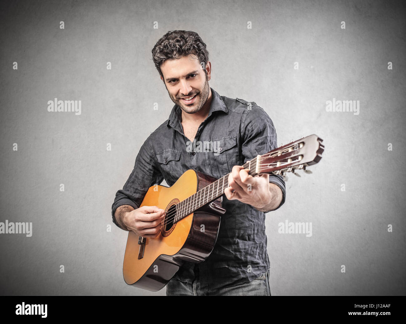 Uomo bello suonare la chitarra Foto Stock