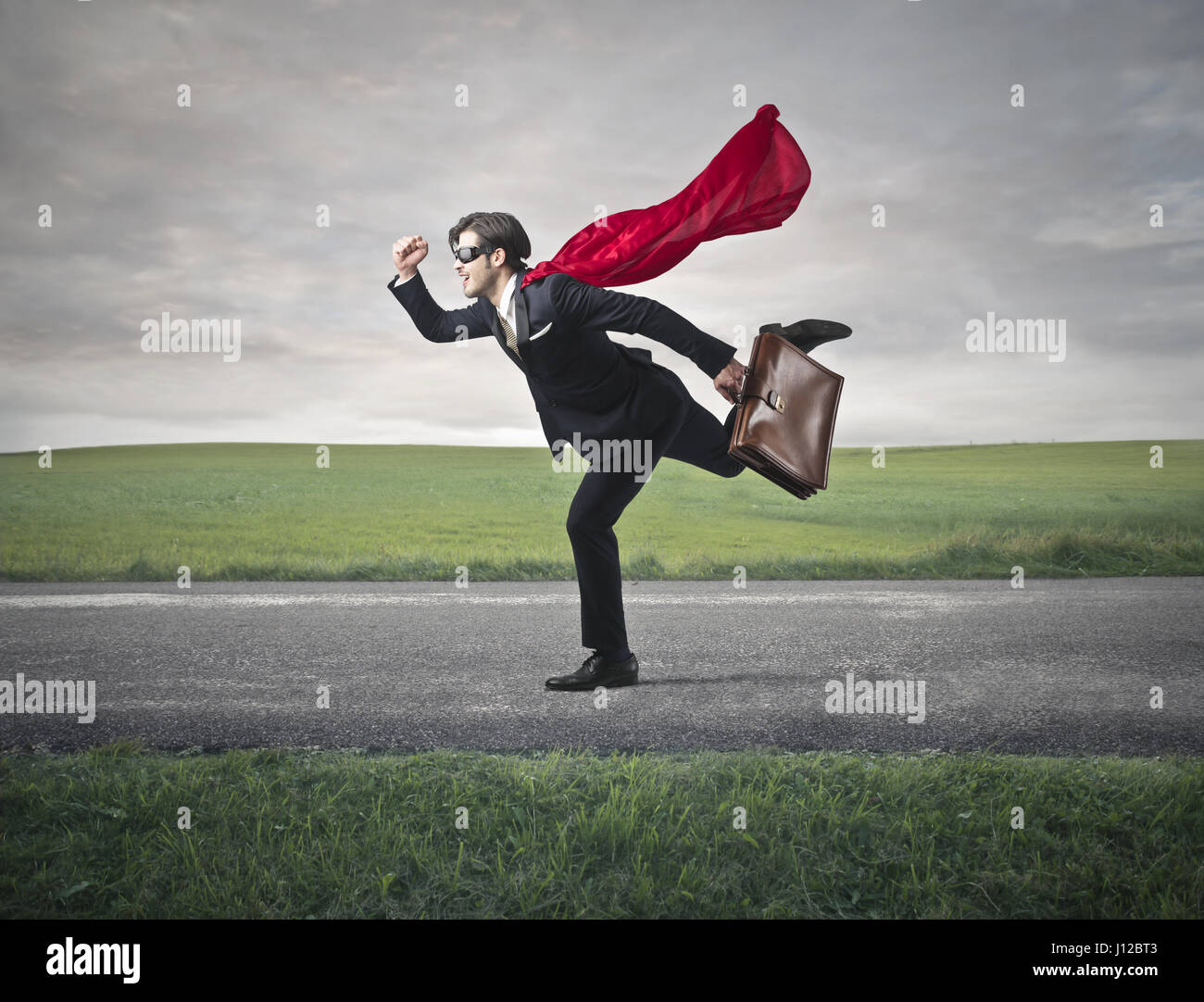 Imprenditore con cape e valigetta Foto Stock