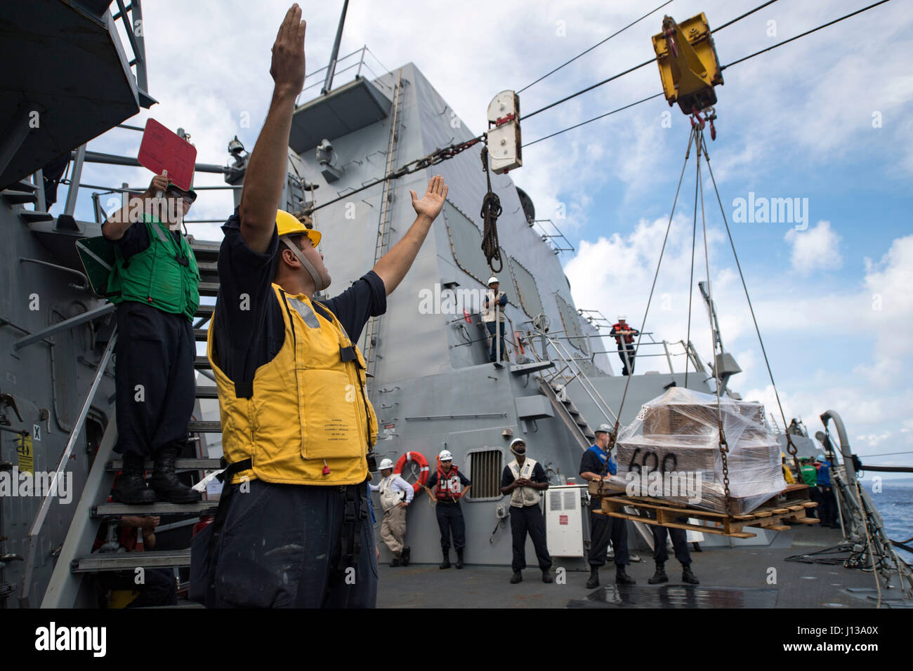 170411-N-pp996-164 sul Mare del Sud della Cina (11 aprile 2017) di Boatswain Mate 2a classe Brandon Torres, da Hemet, Calif,, segnali la flotta oliatore di rifornimento USNS Pecos (T-AO 197) durante un rifornimento in mare a bordo del Arleigh Burke-class guidato-missile destroyer Michael Murphy (DDG 112). Michael Murphy è programmata un pacifico occidentale di implementazione con la Carl Vinson Carrier Strike gruppo come parte dell'U.S. Flotta del pacifico-led iniziativa di estendere il comando e le funzioni di controllo di Stati Uniti 3a flotta. Stati Uniti Navy portaerei strike gruppi hanno pattugliato il Indo-Asia-Pacifico regolarmente e rout Foto Stock