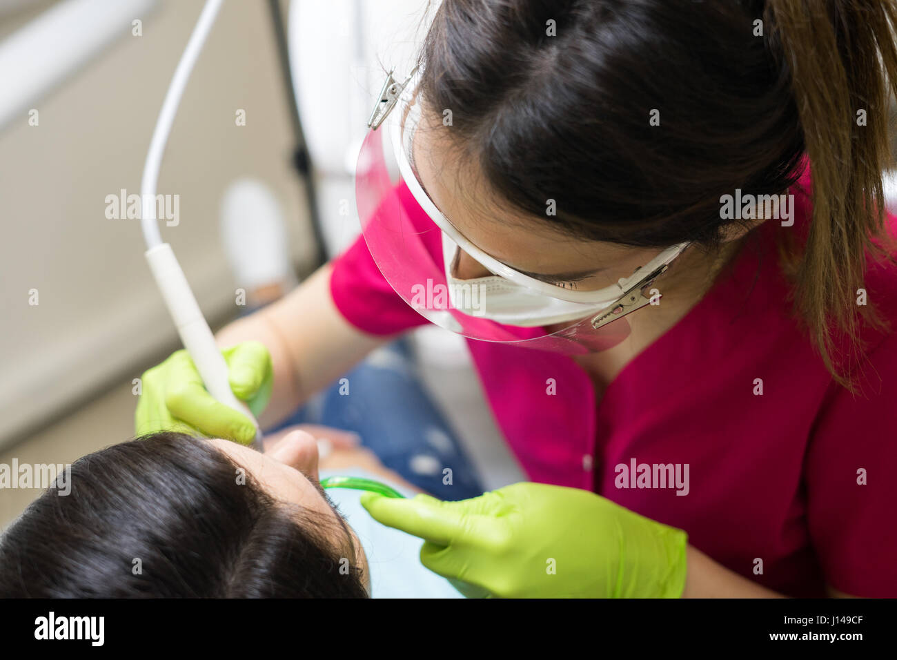 Dentista femmina la pulizia dei denti del paziente Foto Stock