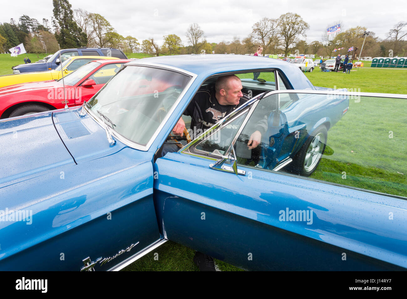 Uomo seduto nella sua rara collezione Ford Mustang classic car Foto Stock