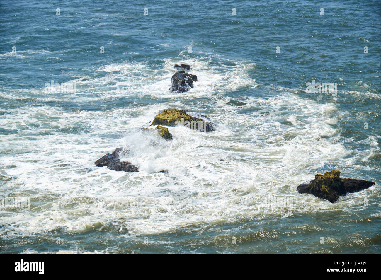 Rocce e onde di navigare nell'oceano vicino Farol De Nazare costa, in prossimità della città portoghese nazare, Portogallo Foto Stock