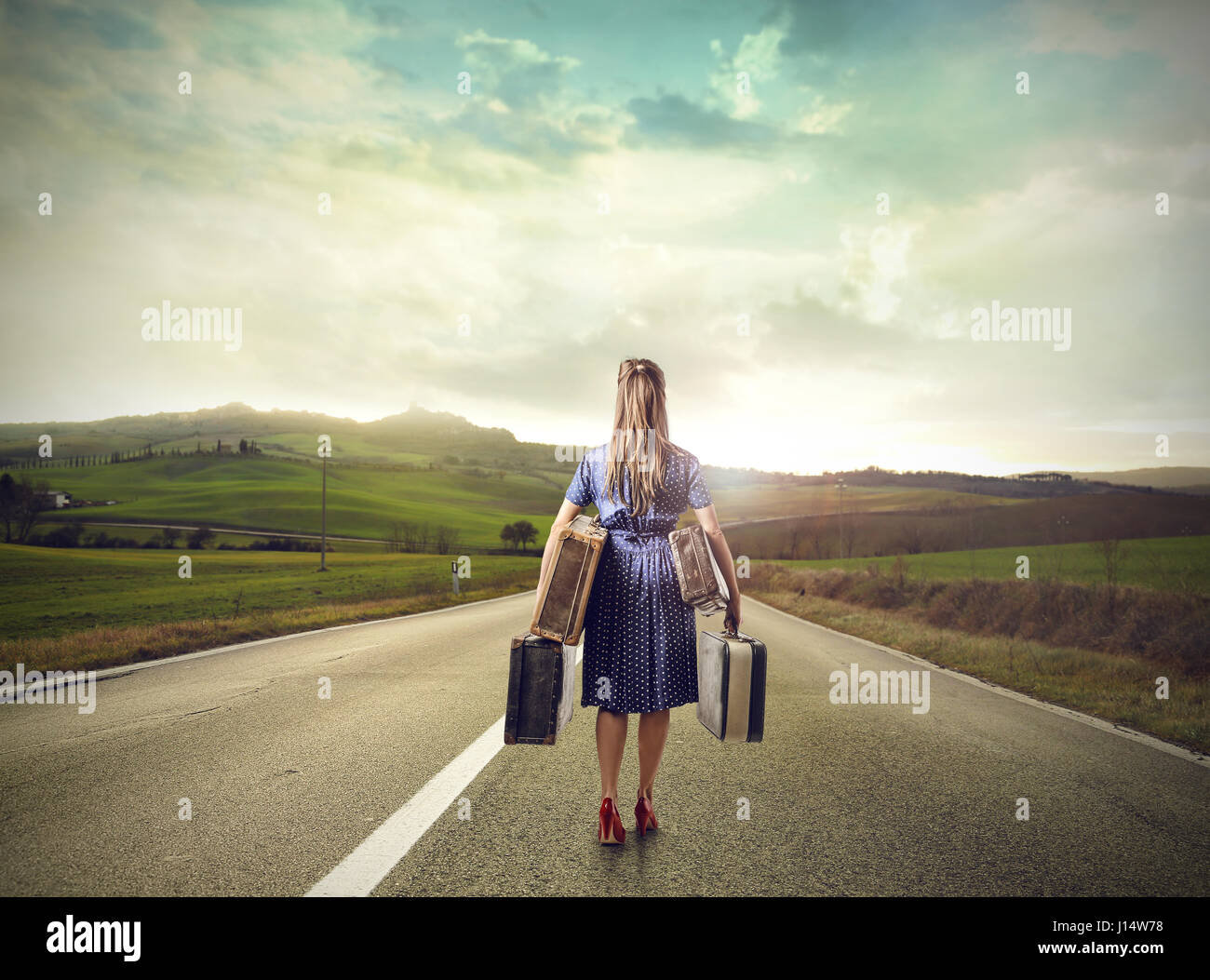 Donna su autostrada con bagagli Foto Stock