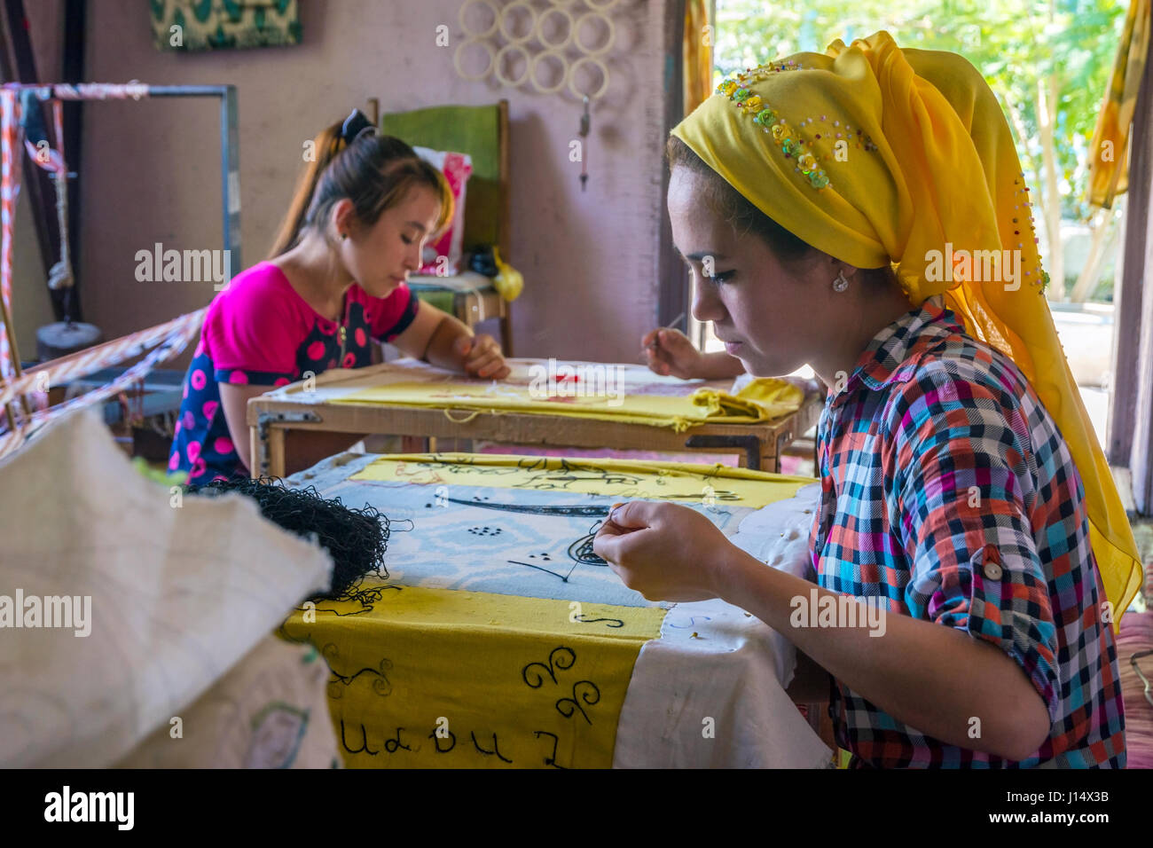 MARGILAN, Uzbekistan - 20 agosto: donna tessuto da ricamo a mano con i tradizionali modelli uzbeko in una fabbrica di seta workshop. Agosto 2016 Foto Stock