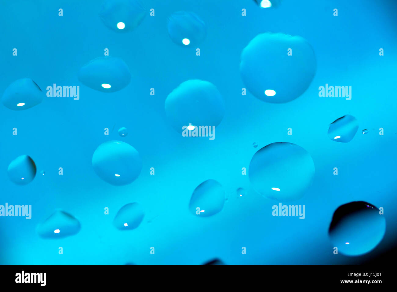 Sfondo astratto con gocce di olio su blu Foto Stock