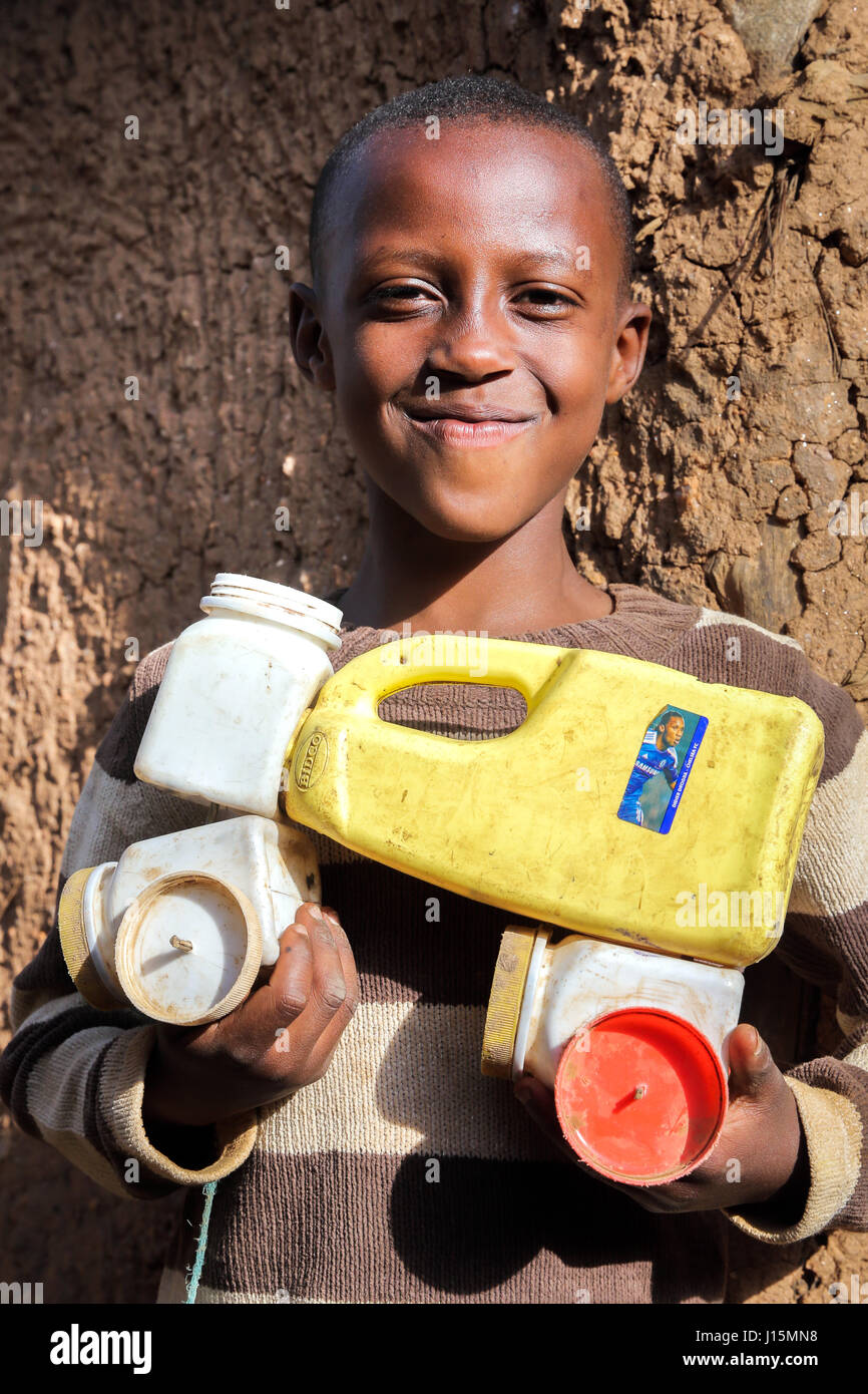 I bambini rifugiati dalla Repubblica Democratica del Congo nell'UNHCR Kigeme Refugee Camp con self-made auto giocattolo di lattine in plastica. Diocesi di Gikongoro, in Rwanda, Africa Foto Stock
