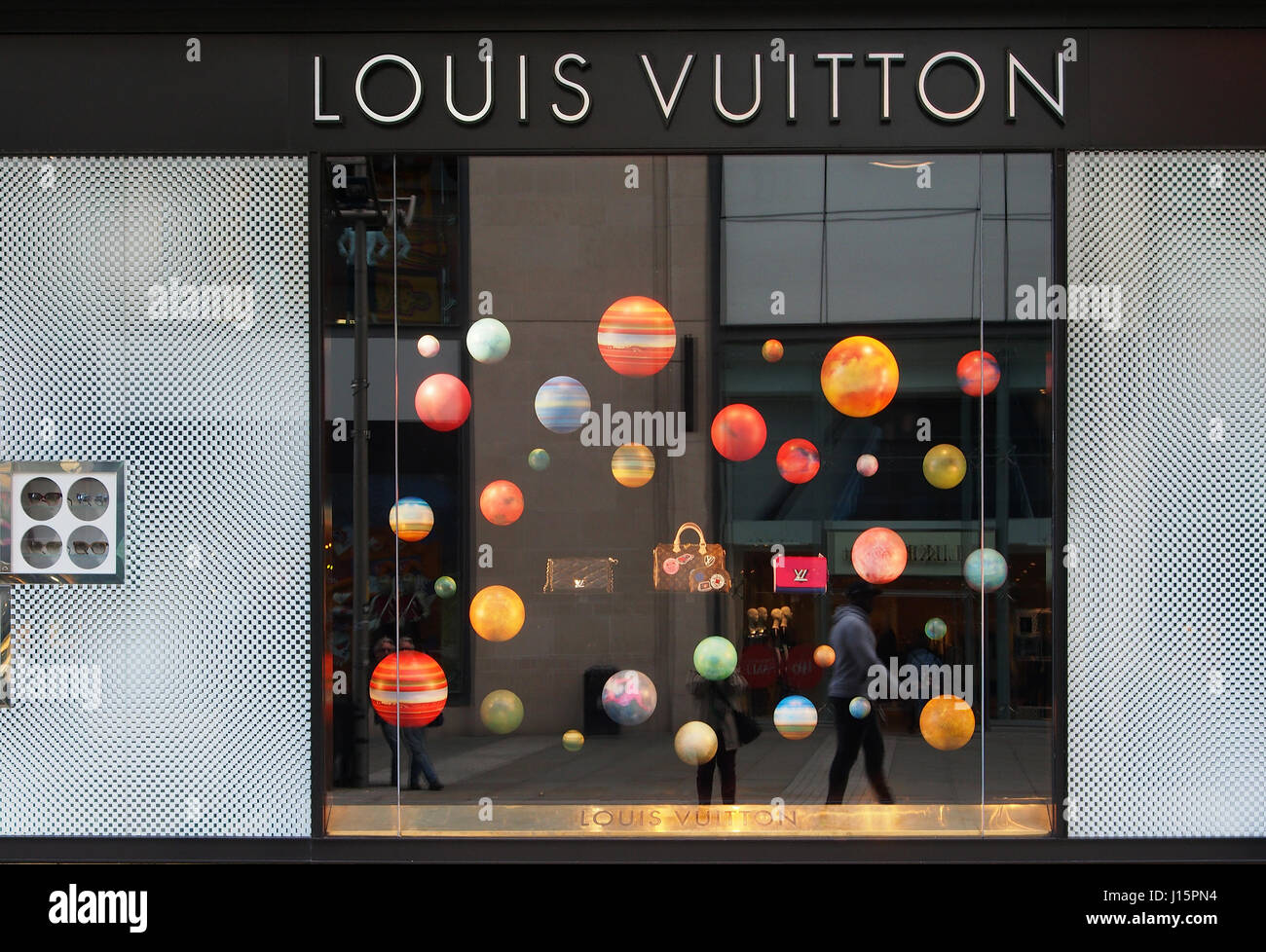 Colorato colorato la finestra di visualizzazione del Louis Vuitton shop store nel centro città centro di Manchester, Inghilterra, Regno Unito con borsette e profumo. Foto Stock