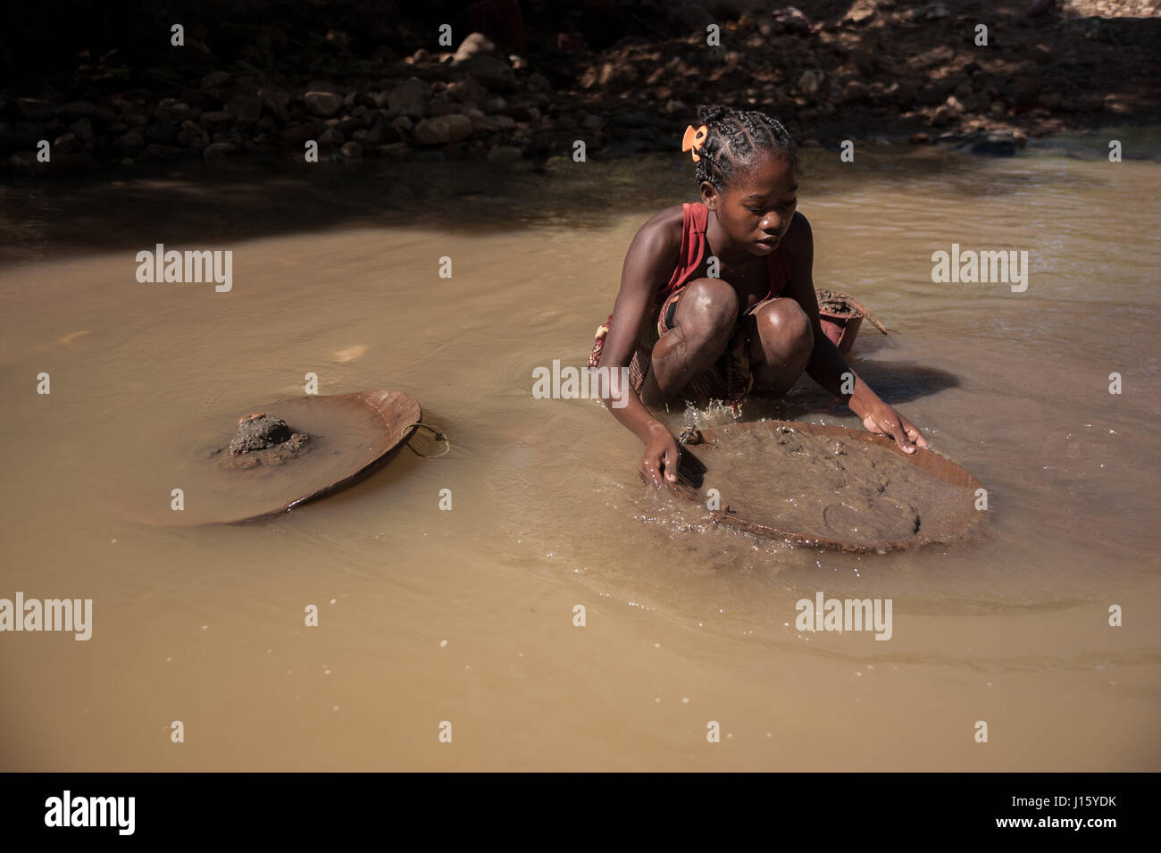 Una giovane ragazza manca scuola al PAN per l'oro nelle montagne vicino Ankavandra, Madagascar Foto Stock