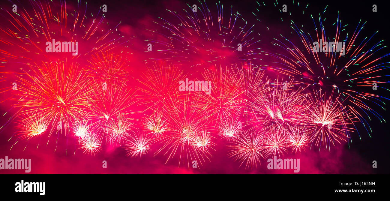 Fuochi d'artificio multicolore con cityscape di notte Foto Stock