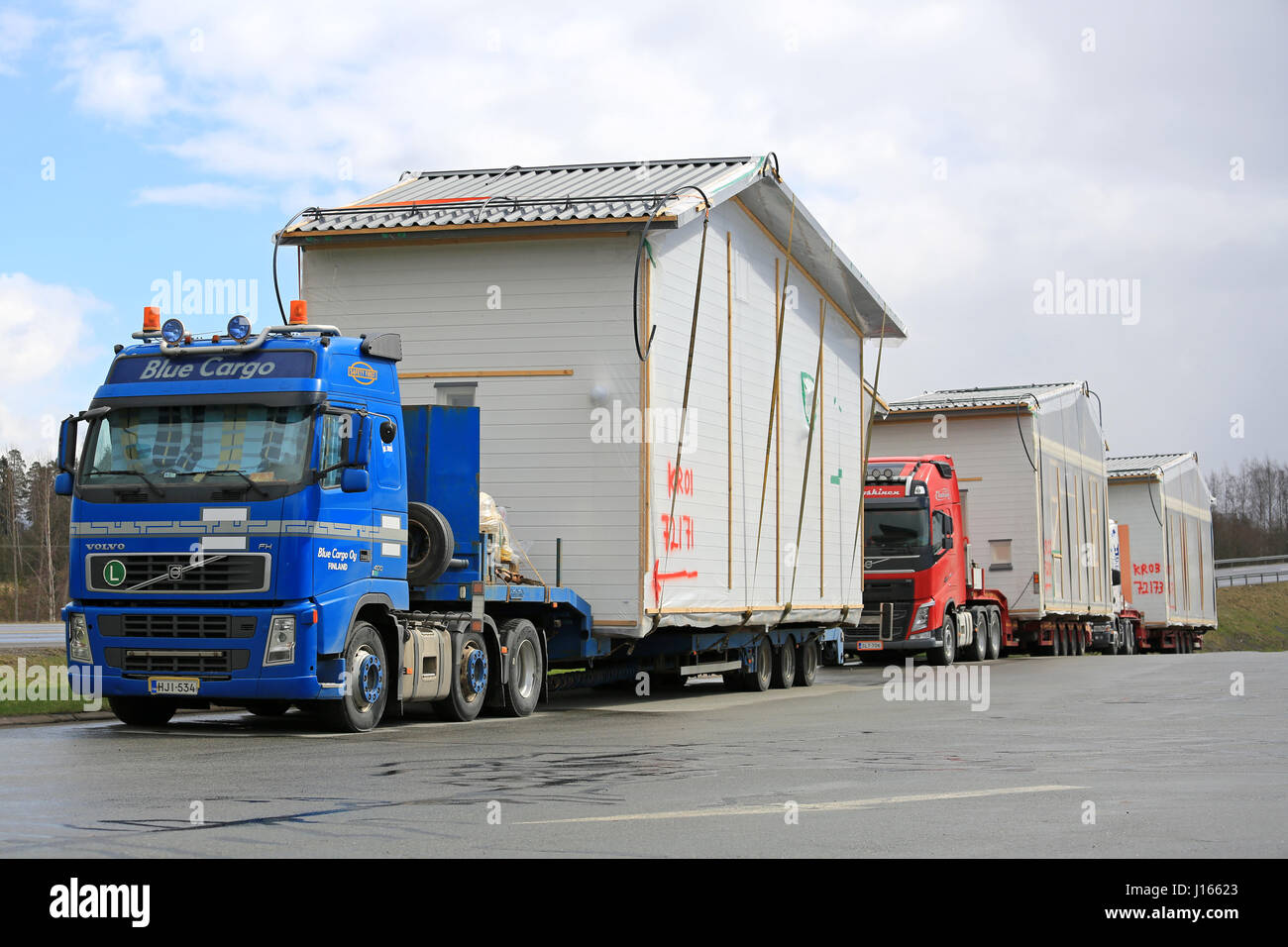 FORSSA, Finlandia - 23 Aprile 2016: convoglio di tre camion, blu Volvo FH semi rimorchio prima, sono parcheggiate su un truck stop durante un trasporto di prefabric Foto Stock