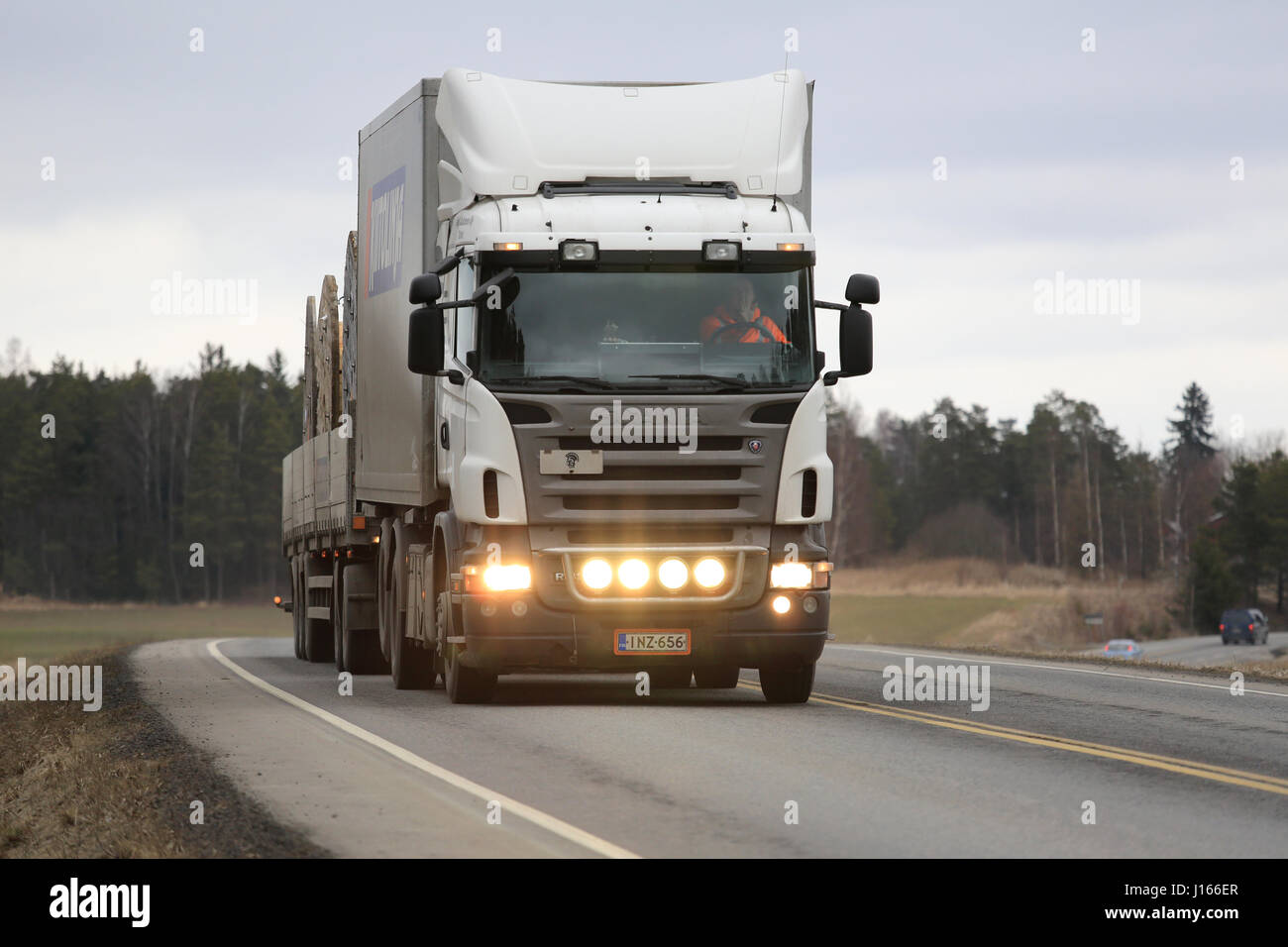 SALO, Finlandia - 24 Marzo 2016: Bianco autocarro Scania e una combinazione di rimorchio si muove lungo l'autostrada nel sud della Finlandia. Il driver lampeggia il fascio abbagliante l Foto Stock