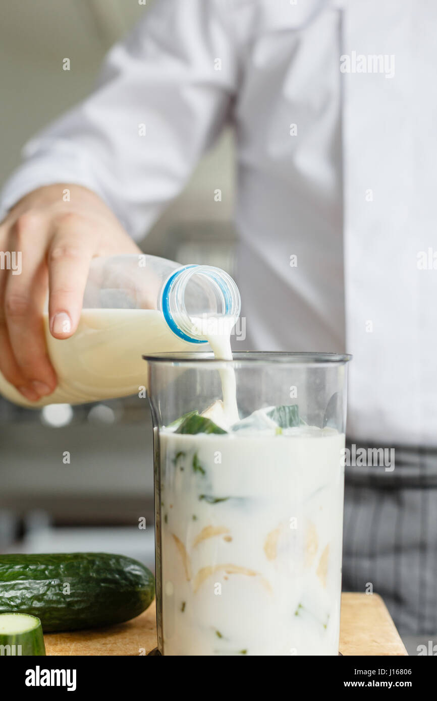 Maschio di latte di colata durante la preparazione di frullati Foto Stock