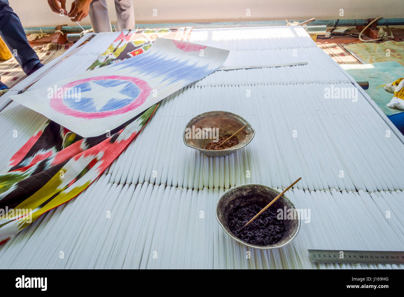 Workshop di morire di seta e la produzione di tessuti di seta con tradizionali motivi uzbeka, Uzbekistan Foto Stock