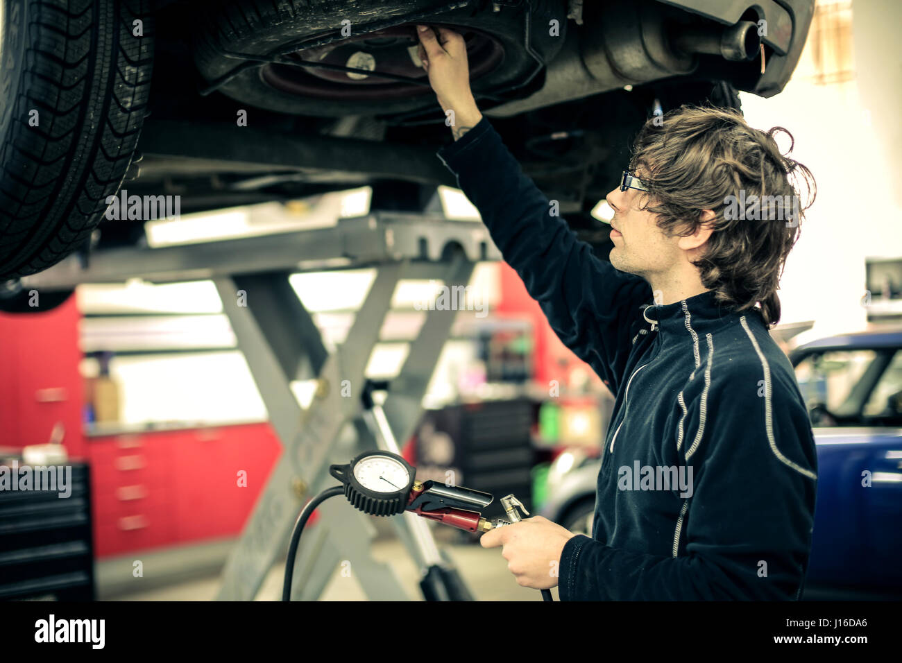 Uomo meccanico a lavorare sulla vettura Foto Stock