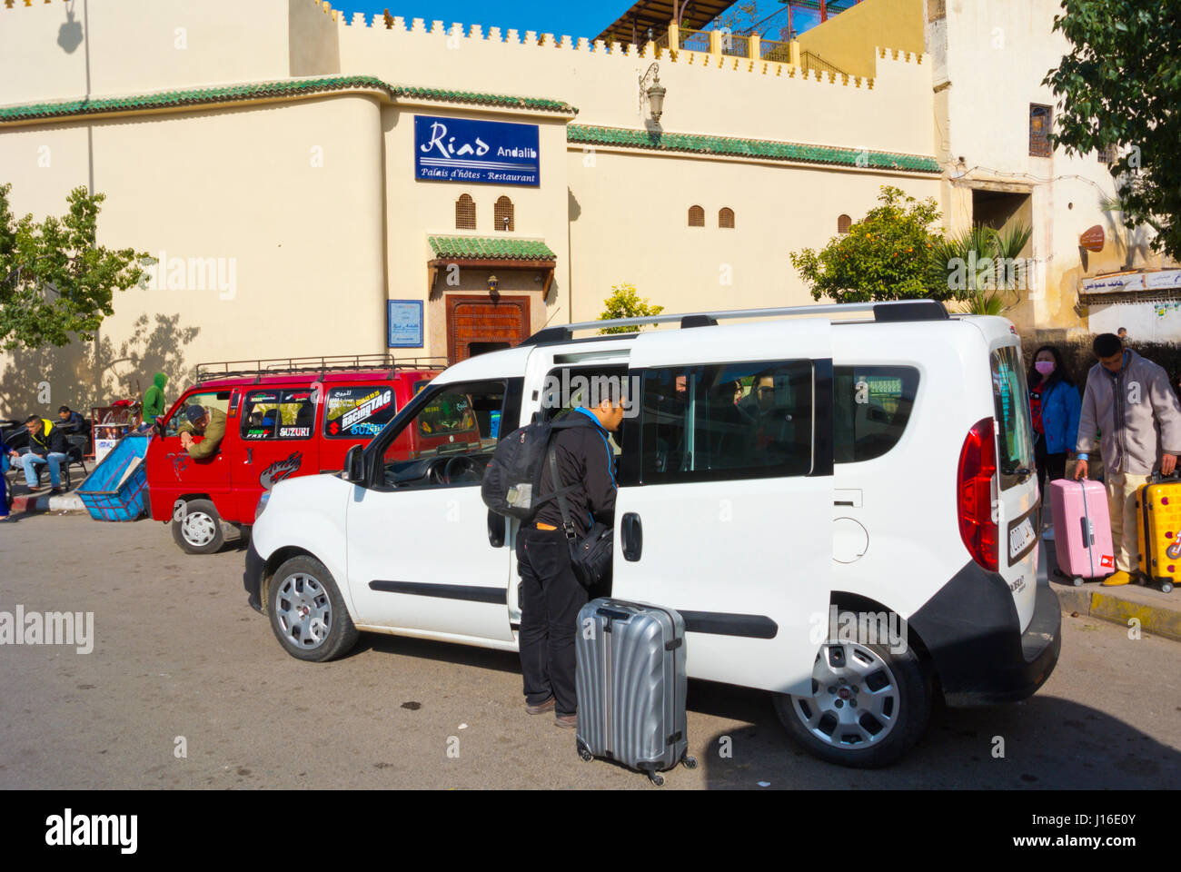 I turisti di arrivare a un grand taxi, a fronte di un hotel, quartiere andaluso, Fez, in Marocco, Africa Foto Stock