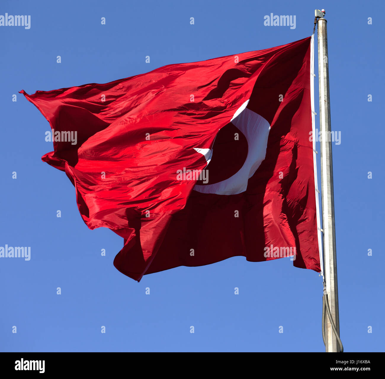 Bandiera turca sul pennone sventolare nel vento in un cielo blu Foto Stock