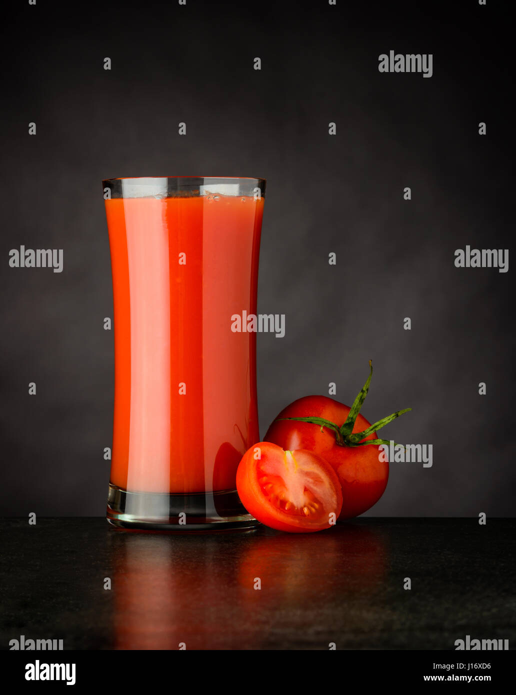 Naturale e biologica rosso succo di pomodoro bere su sfondo scuro Foto Stock