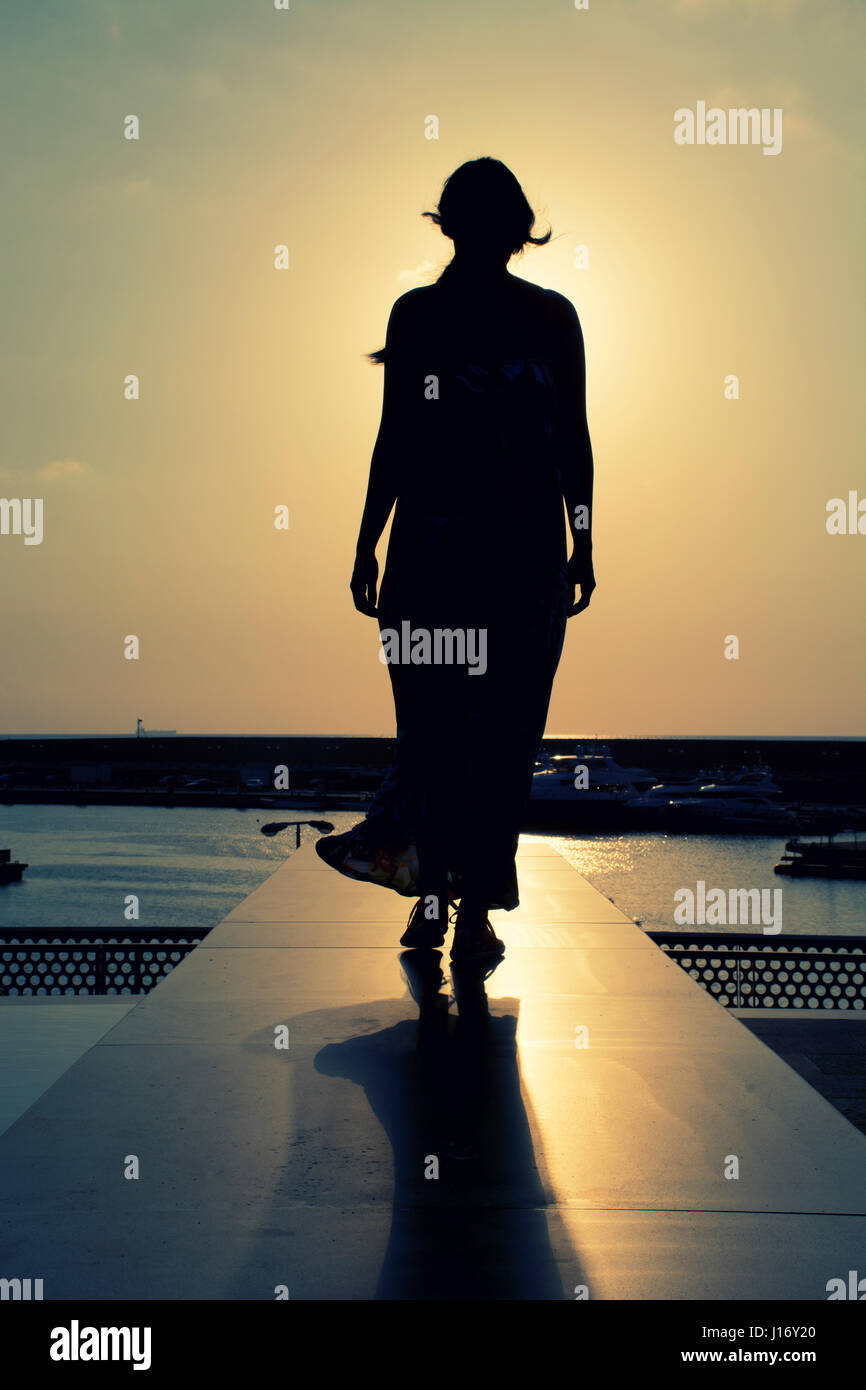 Lunghezza completa silhouette di donna al tramonto Foto Stock
