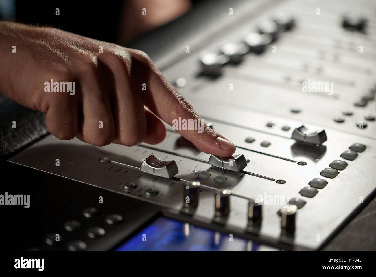 Mano con console di miscelazione in music studio di registrazione Foto Stock