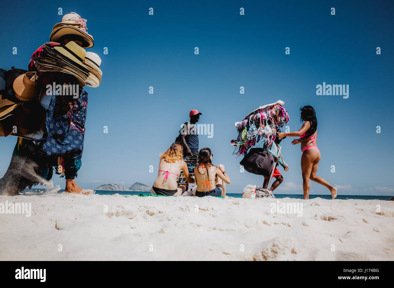 I venditori di strada che cercano di attirare clienti presso la spiaggia di Ipanema, Rio de Janeiro, Brasile Foto Stock