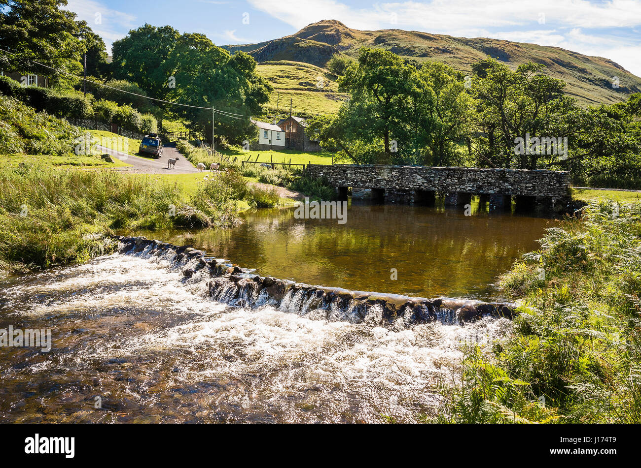 Di schiuma di acque che scorrono su uno stramazzo sul Martindale Beck Cumbria Inghilterra England Regno Unito Foto Stock