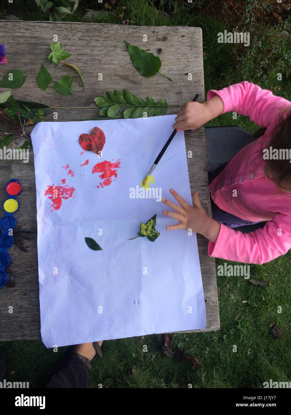 Close up della bambina a sperimentare la pittura su carta, sopra visualizza Foto Stock