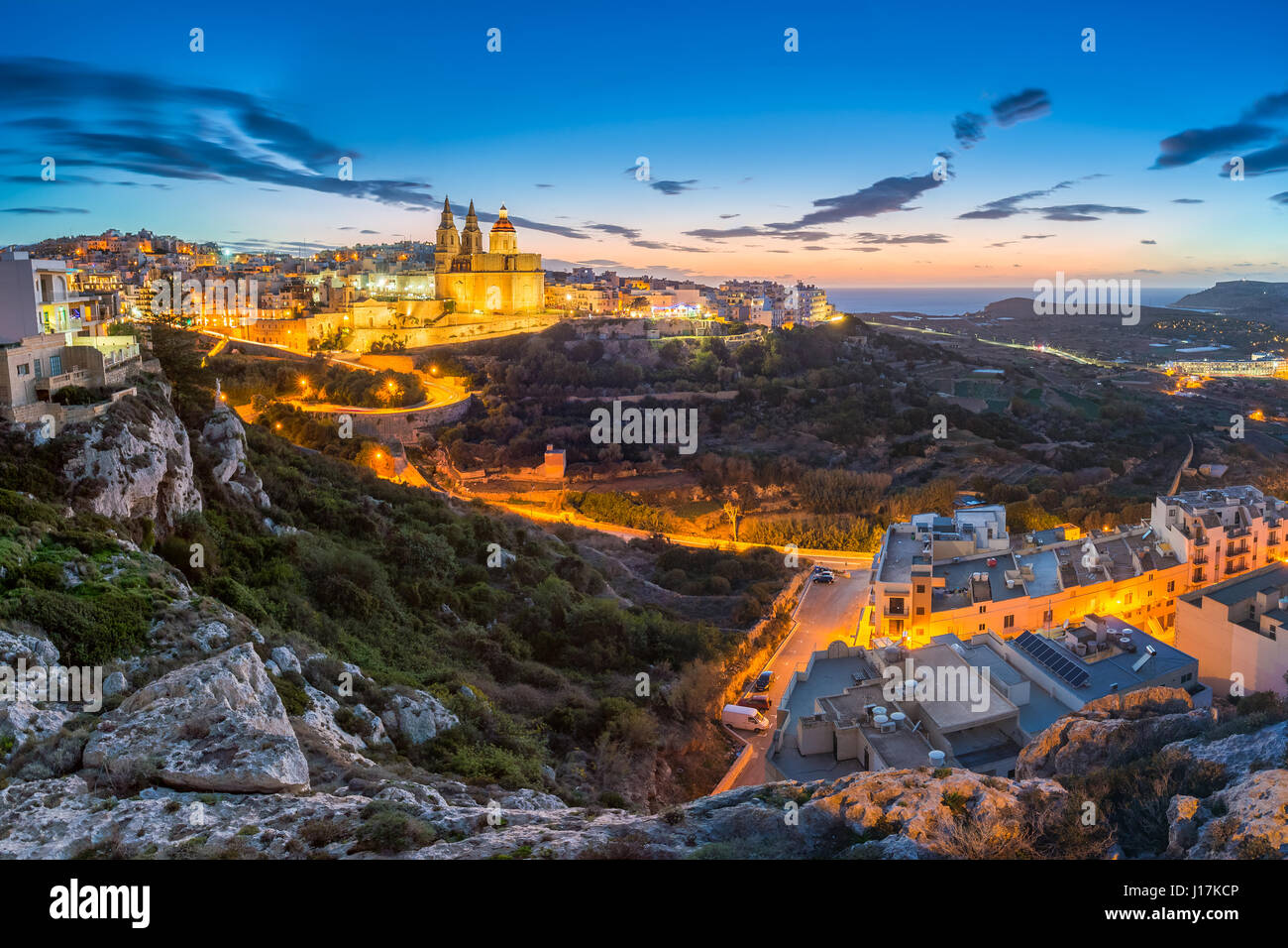 Il-Mellieha, Malta - splendida vista sullo skyline della città di Mellieha dopo il tramonto con Parigi Chiesa di Mellieha e Spiaggia di sfondo con cielo blu un Foto Stock