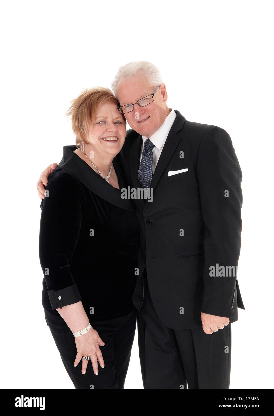 Una bella coppia di anziani in piedi in abiti, abbracciando ogni altro in lunghezze completo isolato per sfondo bianco. Foto Stock