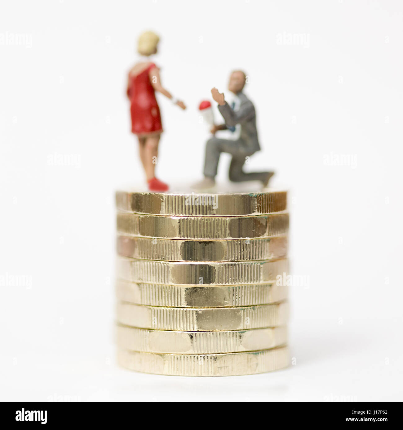 Close up/modello macro stock foto raffiguranti proposta di matrimonio uomo alle donne sulla pila di nuovo Sterlina (£) monete. Foto Stock