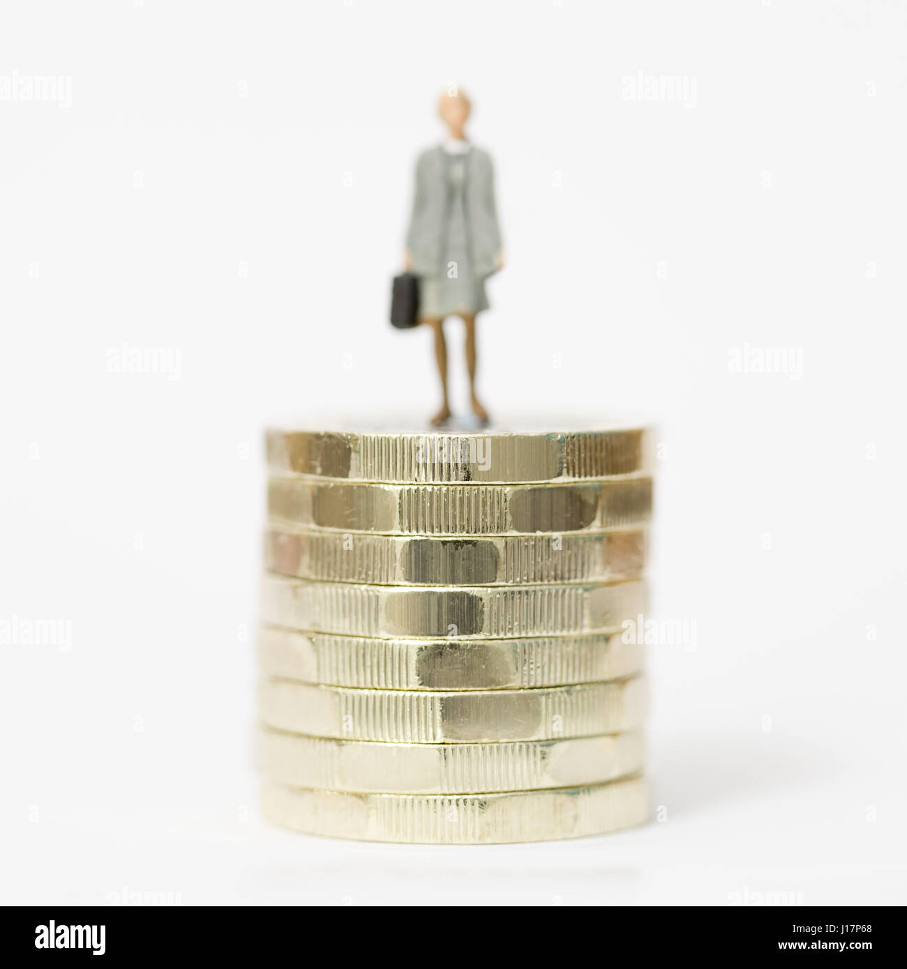 Close up/modello macro stock foto raffiguranti femmina lavoratore salariale sulla pila di nuovo British pound monete. Foto Stock