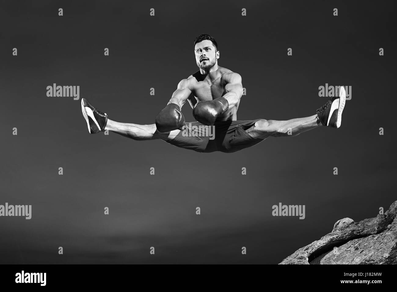 Atleta maschio facendo si divide in aria durante il salto Foto Stock