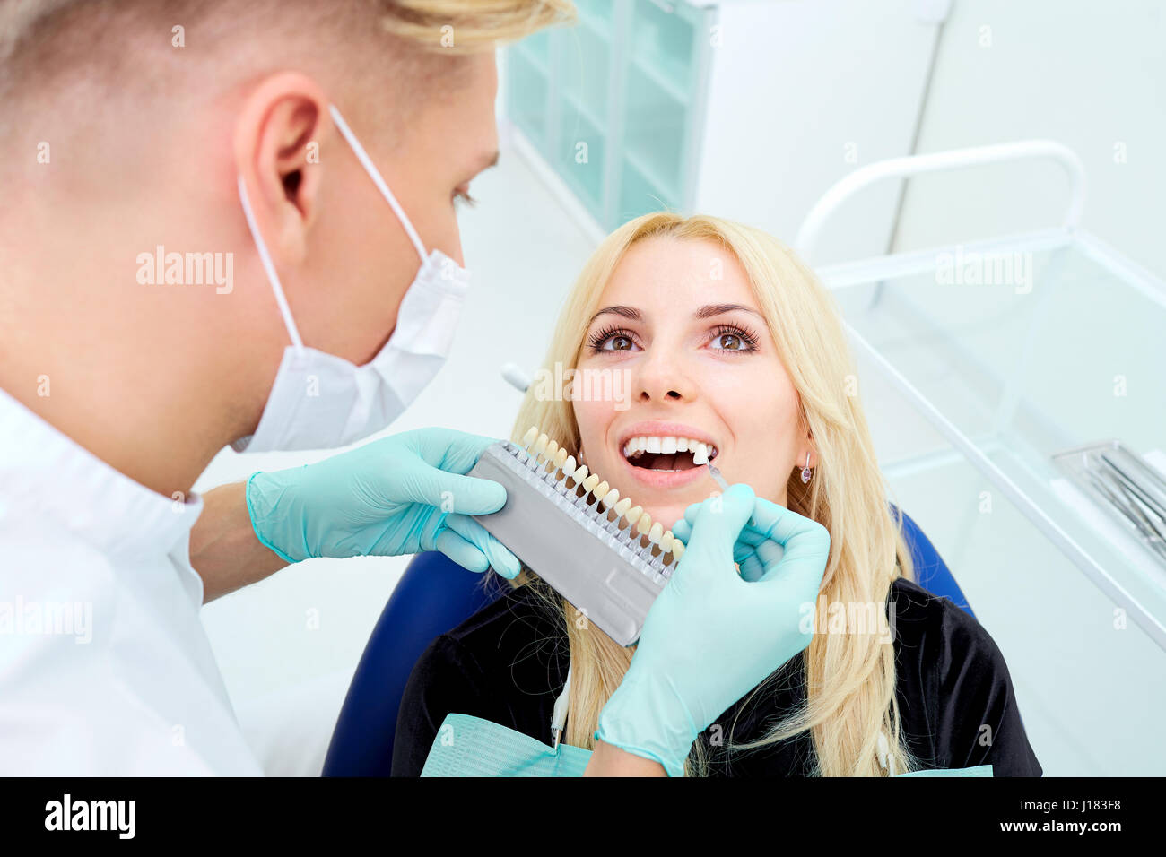 Dentista cerca di scegliere il colore dei denti e il client di Office Foto Stock