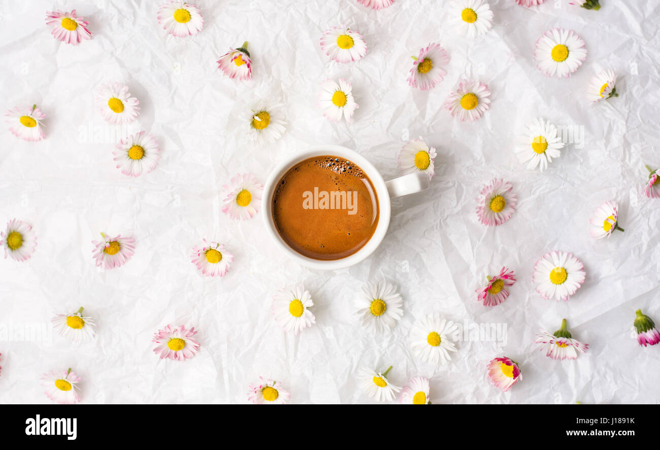 Tazza di caffè e daisy fiori sul tessuto bianco Foto Stock