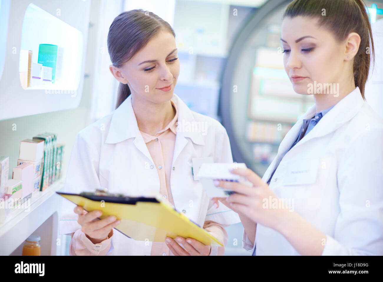 Farmacisti tenendo stock in farmacia Foto Stock