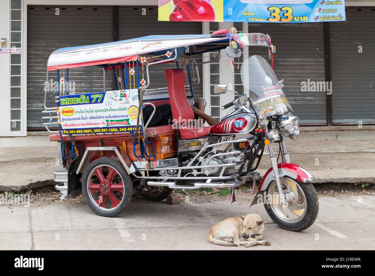 Un Tuk Tuk nel nord-est della Thailandia e cane Foto Stock