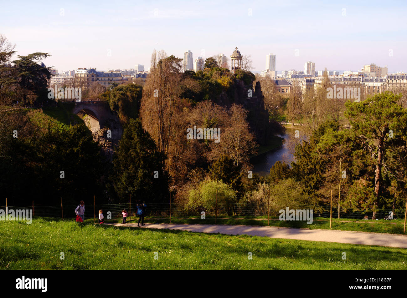 Una famiglia a piedi lungo un sentiero nel parco Buttes-Chaumont, Parigi, Francia Foto Stock