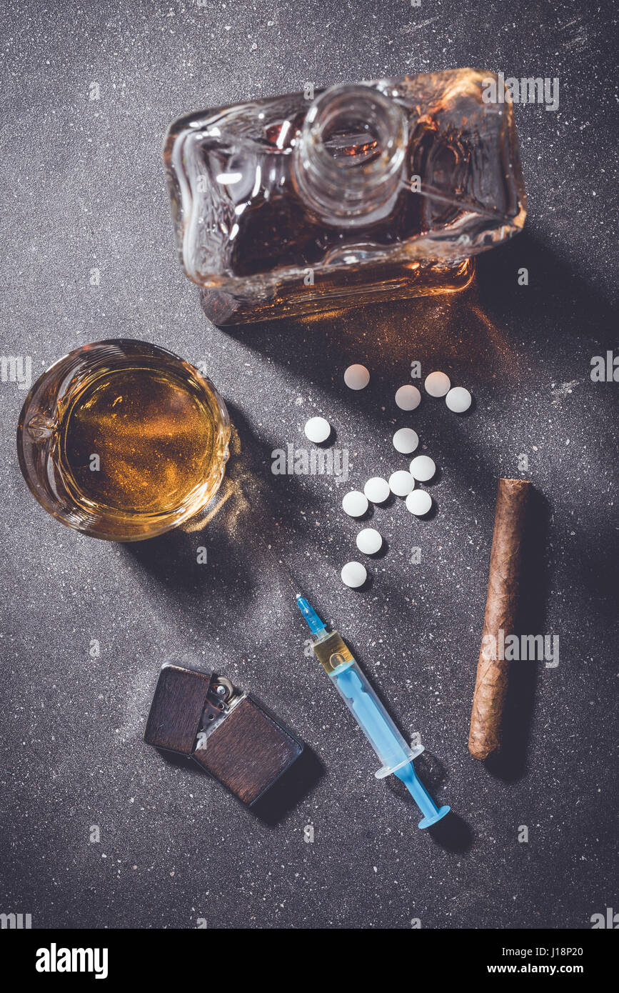 Droghe e alcol in pietra scura tabella. Vista superiore Foto Stock