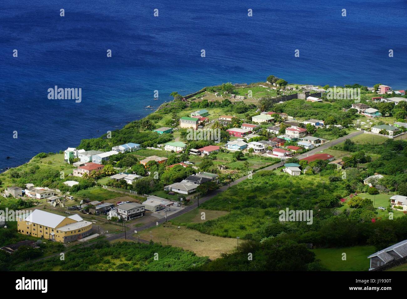Una vista dall'alto sulla riva del mare di Saint Kitts Island, Saint Kitts e Nevis con edifici residenziali, strade e acqua di mare in una luminosa giornata di sole. Foto Stock