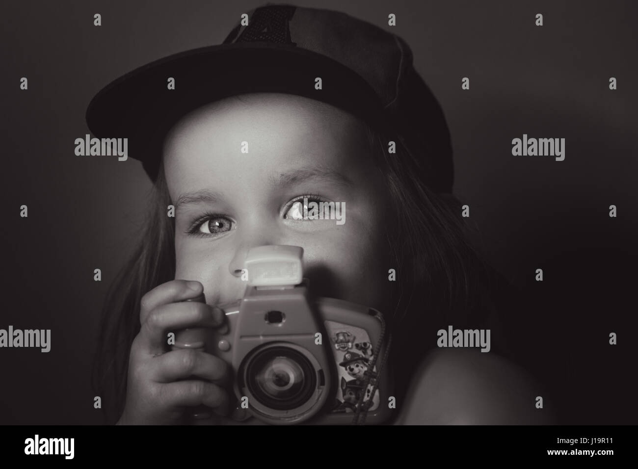 Ragazza tenendo la foto con la fotocamera del giocattolo Foto Stock
